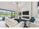 Bright living room boasts a fireplace, large TV, high ceilings, white sofa, and pool view at 12409 Gentle Swan Pl, Odessa, FL 33556
