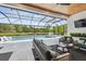 Screened-in outdoor living area features a pool, lake views, and comfortable seating, perfect for relaxation at 12409 Gentle Swan Pl, Odessa, FL 33556