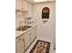 Compact kitchen featuring white cabinets, a stainless steel sink, and modern appliances at 1257 Drew St # 8, Clearwater, FL 33755