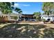 Wide backyard view featuring a well-manicured lawn, patio, pergola, and other landscaping at 1655 Owen Dr, Clearwater, FL 33759