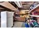 A basement with wood-paneled walls, cabinets, pegboard, and a white refrigerator at 1655 Owen Dr, Clearwater, FL 33759