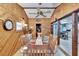 Cozy dining room features wood paneling, stylish ceiling fan, and seating for six around a glass-top table at 1655 Owen Dr, Clearwater, FL 33759