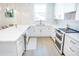 Open kitchen featuring white cabinets, marble countertops, stainless steel appliances, and hardwood flooring at 1725 Massachusetts Ne Ave, St Petersburg, FL 33703