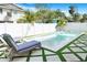 Relaxing poolside view with lounge chairs, turf, and pavers creating a serene backyard retreat at 1725 Massachusetts Ne Ave, St Petersburg, FL 33703
