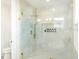 Modern shower with glass doors, luxurious gold accents, and white tile surround with a niche at 1725 Massachusetts Ne Ave, St Petersburg, FL 33703