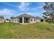 Backyard featuring a grassy lawn and covered patio, blending indoor and outdoor living at 19624 Lonesome Pine Dr, Land O Lakes, FL 34638
