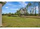 Spacious backyard featuring a pond, green grass, and scattered trees at 19624 Lonesome Pine Dr, Land O Lakes, FL 34638