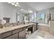 Bright bathroom with double vanity, granite countertops, and soaking tub at 19624 Lonesome Pine Dr, Land O Lakes, FL 34638