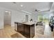 Modern kitchen featuring a dark wood island, granite countertops, stainless steel appliances, and open access to the living room at 19624 Lonesome Pine Dr, Land O Lakes, FL 34638