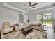 Comfortable living room with neutral colors, lots of seating, a ceiling fan, and sliding glass doors to the outside at 19624 Lonesome Pine Dr, Land O Lakes, FL 34638