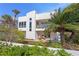 Stylish home featuring a second-story balcony and patio with seating, surrounded by lush greenery at 2003 Gulf Way, St Pete Beach, FL 33706