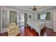 Bright bedroom with wood floors, ceiling fan, and adjacent enclosed porch at 2202 Clubhouse Dr # 174, Sun City Center, FL 33573
