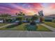Charming single-story home with well-maintained landscaping and a beautiful sunset in the sky at 2202 Clubhouse Dr # 174, Sun City Center, FL 33573