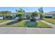 Street view of the home featuring lush landscaping, green grass, and an inviting entrance at 2202 Clubhouse Dr # 174, Sun City Center, FL 33573
