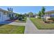 Neighborhood street view of the home featuring lush landscaping and green grass at 2202 Clubhouse Dr # 174, Sun City Center, FL 33573