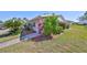 Side street view of home with lush landscaping, featuring red and green plants at 2202 Clubhouse Dr # 174, Sun City Center, FL 33573