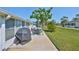 Outdoor patio area featuring table and chairs, with a grill with cover on the back of the home at 2202 Clubhouse Dr # 174, Sun City Center, FL 33573