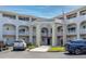 Three-story building featuring an ornate entrance, well-maintained landscaping, and a nearby parking lot at 2229 Americus W Blvd # 25, Clearwater, FL 33763