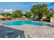 Large community pool surrounded by lounge chairs and shade umbrellas at 2229 Americus W Blvd # 25, Clearwater, FL 33763