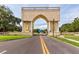 Ornate stone archway entrance to community with manicured lawns and landscaping at 2229 Americus W Blvd # 25, Clearwater, FL 33763