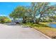 Three-story building with green trees and lawn and lake in the background at 2229 Americus W Blvd # 25, Clearwater, FL 33763