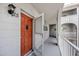The front door of a condo with a storm door and a side view of the shared outdoor landing at 2229 Americus W Blvd # 25, Clearwater, FL 33763