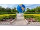 Large globe sculpture surrounded by manicured hedges and colorful flowers at 2229 Americus W Blvd # 25, Clearwater, FL 33763