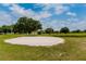 Large sand trap surrounded by green grass and mature trees on the golf course at 2229 Americus W Blvd # 25, Clearwater, FL 33763