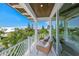 Outdoor balcony with seating area and views of lush greenery and blue skies at 311 Spring Ave, Anna Maria, FL 34216