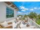Outdoor balcony with seating area and views of lush greenery and blue skies at 311 Spring Ave, Anna Maria, FL 34216