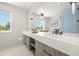 Bright bathroom featuring double sinks, modern lighting, and a large window for natural light at 311 Spring Ave, Anna Maria, FL 34216