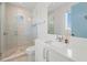 Bathroom featuring a glass shower, round window, and modern fixtures, showcasing the bright and stylish space at 311 Spring Ave, Anna Maria, FL 34216