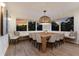 Dining room boasts large windows, sunset views, a modern chandelier, and seating for eight, perfect for entertaining guests at 311 Spring Ave, Anna Maria, FL 34216