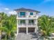 Stunning two-story home with double balconies and tropical landscaping at 311 Spring Ave, Anna Maria, FL 34216