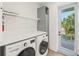 Bright laundry room featuring modern appliances, white countertops, and access to outdoor area at 311 Spring Ave, Anna Maria, FL 34216