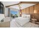 Bright main bedroom with woven accent wall, light wood ceiling beams, and access to a private balcony at 311 Spring Ave, Anna Maria, FL 34216