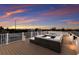 An expansive rooftop deck provides ample seating with panoramic views at twilight at 311 Spring Ave, Anna Maria, FL 34216