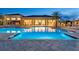 An inviting community pool featuring ample seating and an illuminated clubhouse for evening enjoyment at 32212 Mahogany Valley Dr, Wesley Chapel, FL 33543