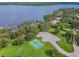 Overhead view of a community park featuring basketball courts, a parking lot, and lake access at 3398 Pinnacle S Ct, Palm Harbor, FL 34684