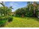 Well-manicured backyard featuring lush greenery, mature trees, and privacy landscaping at 3398 Pinnacle S Ct, Palm Harbor, FL 34684
