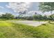 Community basketball court surrounded by lush green grass and mature trees at 3398 Pinnacle S Ct, Palm Harbor, FL 34684