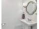 Stylish bathroom showcases a decorative mirror, pedestal sink, and modern fixtures at 3398 Pinnacle S Ct, Palm Harbor, FL 34684