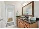 Bathroom features a granite countertop, wooden cabinetry, and a decorative mirror at 3398 Pinnacle S Ct, Palm Harbor, FL 34684
