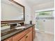 Bathroom features granite counters, wooden cabinetry, a glass shower, and natural light at 3398 Pinnacle S Ct, Palm Harbor, FL 34684