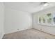Bright bedroom featuring neutral carpet floors and plantation shutters at 3398 Pinnacle S Ct, Palm Harbor, FL 34684