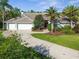 Charming single-story home with a three-car garage, lush landscaping, and a welcoming front entrance at 3398 Pinnacle S Ct, Palm Harbor, FL 34684