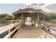 Picturesque gazebo on a wooden pier overlooking a serene lake with a fountain feature at 3398 Pinnacle S Ct, Palm Harbor, FL 34684