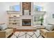 Inviting living room with a stone fireplace, built-in shelving, hardwood floors, and plenty of natural light at 3398 Pinnacle S Ct, Palm Harbor, FL 34684