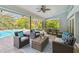 Screened-in patio with outdoor furniture and view of the pool and landscaping at 3398 Pinnacle S Ct, Palm Harbor, FL 34684