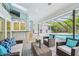 Outdoor living space with comfortable seating, bar, grill, and pool view at 3398 Pinnacle S Ct, Palm Harbor, FL 34684